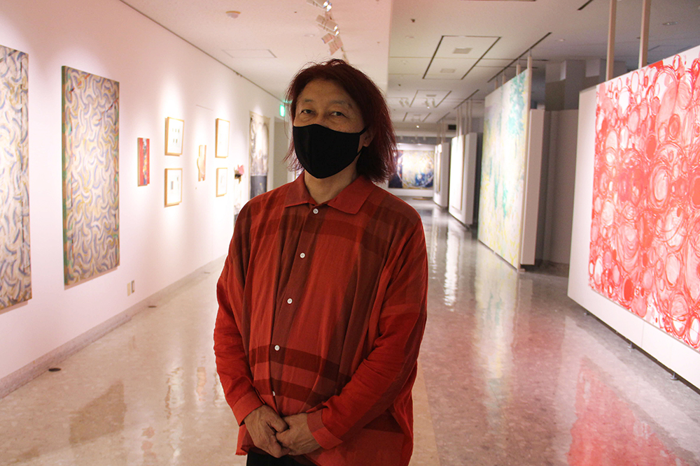 展示物をバックに関口氏